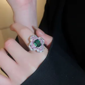 Gros plan d'une bague fleur en zircon vert de luxe sur un doigt