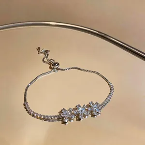 Detailed view of the three-flower zircon cluster on a gold-plated bracelet