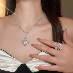 Gros plan sur un ensemble collier et bague de luxe avec fleurs en zircone rose sur modèle