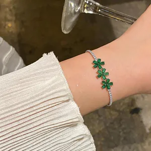 Close-up of elegant emerald green zircon flower bracelet on female wrist.