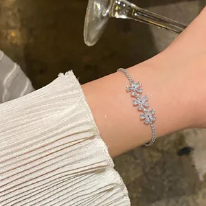 Close-up of sparkling 18k gold-plated flower zircon bracelet worn on a female wrist