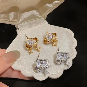 Detailed macro shot of elegant 18K gold and silver plated star stud earrings in a shell box
