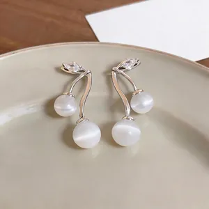 Elegant cherry-shaped earrings with white cat-eye stones and zircon in silver setting