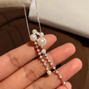 Elegant long necklace featuring white pearls and sparkling zircon tassels on a silver chain