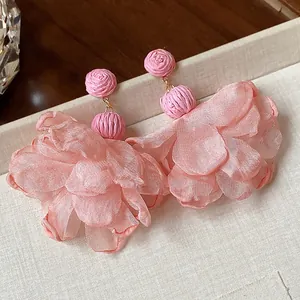 Close-up of pink raffia and chiffon flower earrings for vacation style earrings