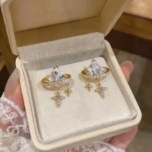 Close-up of 18K gold plated star dangle earrings with square zircon in a jewelry box