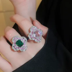 Gros plan de bagues fleurs vintage avec pierres carrées en émeraude et zircon rose