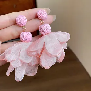 Detailed close-up showing the pink raffia weave and chiffon petals of these elegant earrings