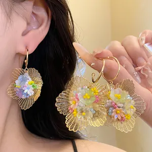 Nahaufnahme von Vintage-Ohrhängern in Blumenform mit bunten Perlen und Goldakzenten