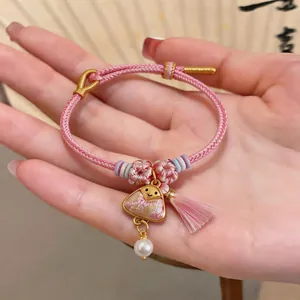 Close-up of pink braided Dragon Boat Festival bracelet with zongzi charm and pearl