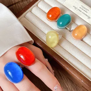 Detail view of colorful vintage oval resin rings presented in a wooden jewelry box