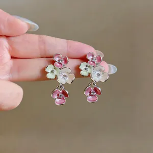 Detailed macro view of multi-colored enamel flower drop earrings with crystal centers