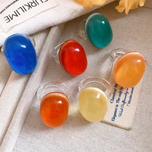 Close-up of vintage oval resin rings in various colors with transparent bands.