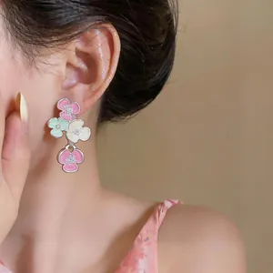 Detail shot of multi-color floral dangle earrings with rhinestones on a model