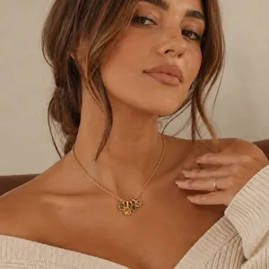 Gros plan d'un modèle portant un collier plaqué or 18 carats avec pendentifs colorés.