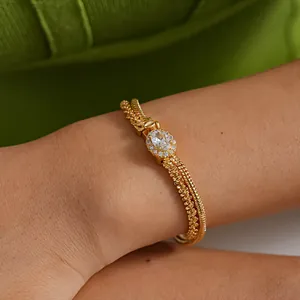 Detail of 18k gold plated double-layer bracelet with oval zircon centerpiece on wrist