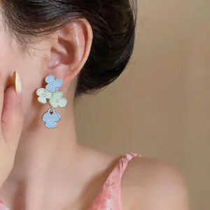 Detailed close-up of colorful pastel floral drop earrings with sparkling crystals