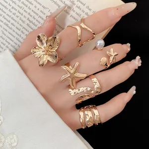 Gros plan détaillé d'un ensemble de 6 bagues dorées vintage avec fleurs et perles