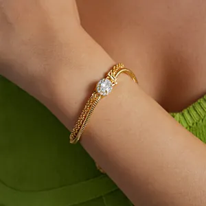Close-up of 18k gold-plated double-layer bracelet with oval zircon on a woman's wrist.