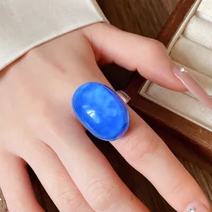 Detail view of a vibrant blue oval resin ring with a vintage minimalist aesthetic