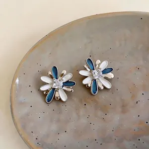 Elegant flower stud earrings with blue and white enamel and central zircon