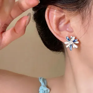 Elegant daisy flower stud earrings with blue and white enamel petals and zircon center