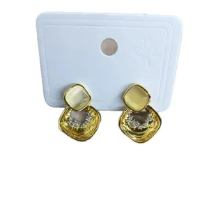 Elegant gold rhomboid stud earrings featuring cat eye stones and sparkling cubic zircons