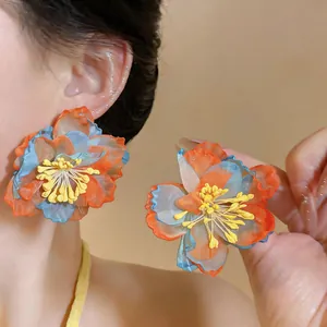 Detailed macro view of vibrant blue and orange chiffon flower earrings with yellow stamens
