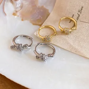 Elegant 14k gold plated knotted hoop earrings featuring sparkling cubic zirconia crystals