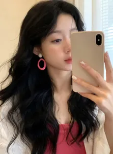 Asian model wearing vibrant pink dopamine-style oval hoop earrings for a trendy look.