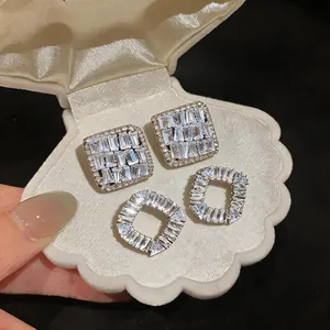 Detailed view of luxury French style cubic zirconia stud earrings in a shell box
