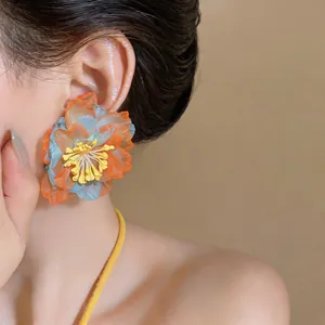 Close-up detail of a colorful forest style chiffon flower earring on an Asian model's ear