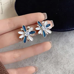 Elegant blue and white enamel flower stud earrings with a central square zircon stone.