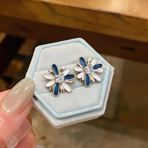 Detail macro view of blue and white oil-drop flower earrings with square zircon center