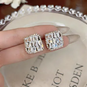 Close-up detail of rhombus zircon stud earrings with sparkling baguette-cut stones