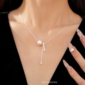 Elegant silver-toned necklace featuring a pleated metal bar and a lustrous pearl bead