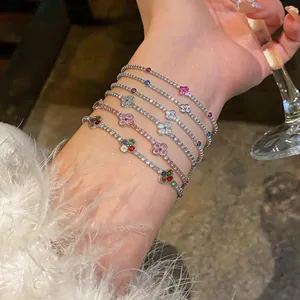 Primo piano di eleganti braccialetti in zircone a fiori su polso sotto luce calda