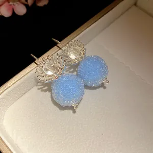 Close-up of elegant blue crystal flower round pendant drop earrings in a jewelry box