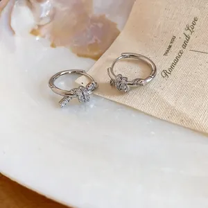 Macro view of 14K gold plated hoop earrings featuring a sparkling zircon-encrusted knot design