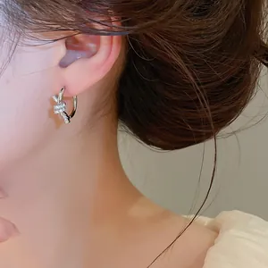 Silver knotted hoop earring with sparkling zircon stones worn by a model in a close-up view