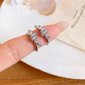 Close-up of elegant silver-toned knot earrings plated with 14k gold and cubic zirconia