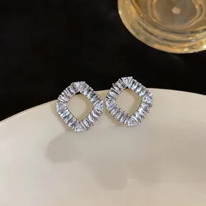 Close-up of sparkling zircon geometric diamond-shaped stud earrings in French style