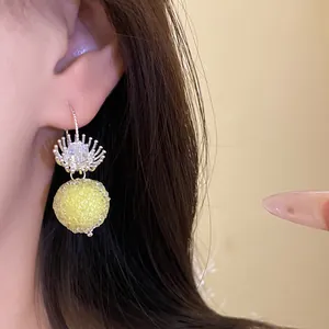 Detailed macro shot of an elegant crystal flower drop earring with a yellow textured bead