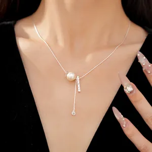 Detailed view of elegant silver pleated necklace with pearl and zircon pendant on model neck.
