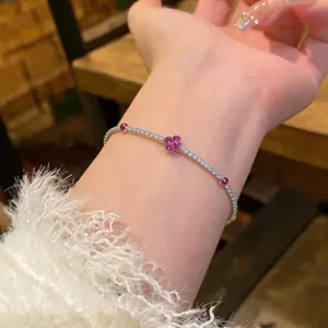 Delicato bracciale in argento con zirconi e motivo a fiore rosa indossato su un polso elegante
