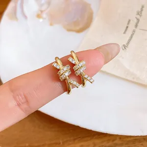 Detail view of 14k gold plated knotted earrings with pavé set cubic zirconia stones