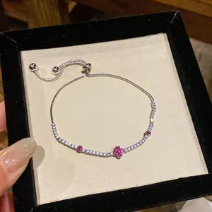 Dettaglio di un braccialetto floreale in argento con zirconi rosa e bianchi lucidi