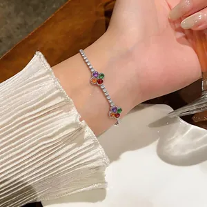 Dettaglio di un bracciale tennis in argento con fiori in zirconi colorati sul polso