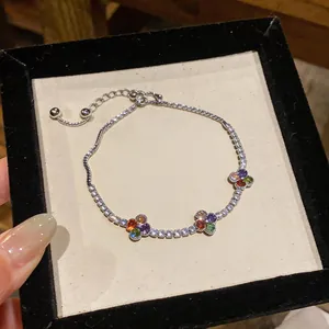 Primo piano di un braccialetto a fiori in argento con zirconi colorati in una scatola