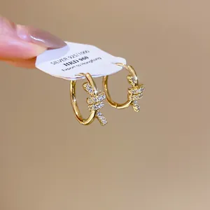Detail view of 14k gold-plated knotted hoop earrings set with sparkling zircon stones